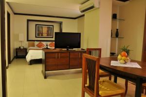 O Hotel في باكولود: غرفة معيشة مع تلفزيون وطاولة طعام