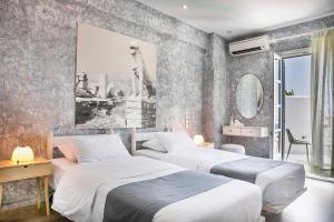ein Schlafzimmer mit 2 Betten und einem Wandgemälde in der Unterkunft Ilio Maris in Mykonos Stadt