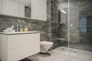 a bathroom with a toilet and a glass shower at Apartment JungfrauCenter Bällenhöchst - GriwaRent AG in Interlaken