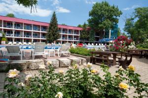 un groupe de chaises et de tables devant un bâtiment dans l'établissement Regina Hotel, à Sunny Beach