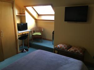 Camera con letto, scrivania e TV. di Orcades Hostel a Kirkwall