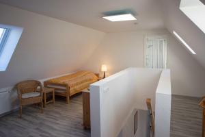 a attic room with a bed and a table at FEWO Maisonettenwohnung in Steinkirchen