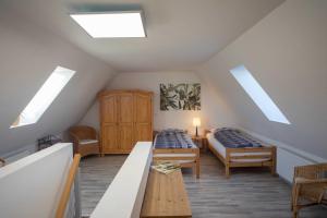 a attic room with two beds and a table at FEWO Maisonettenwohnung in Steinkirchen