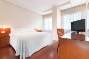a bedroom with a white bed and a television at Hotel Madrid Chamartín, Affiliated by Meliá in Madrid