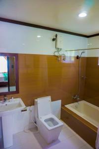 a bathroom with a toilet and a sink and a tub at Veranda Suites and Restaurant in Paoay