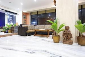 a lobby with a couch and a table and plants at Hotel Niladri in Puri