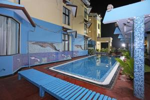 a swimming pool in front of a building at Hotel Niladri in Puri