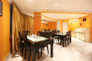 a dining room with tables and chairs and yellow walls at Hotel Niladri in Puri