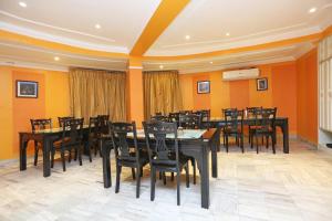a dining room with tables and chairs and orange walls at Hotel Niladri in Puri