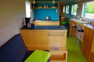 uma pequena cozinha com um balcão e um piso verde em Urlaubsbahnhof-Schlafwagen em Lauterbach