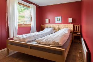 sypialnia z dwoma łóżkami w czerwonej ścianie w obiekcie Lille Randklev Gæstehus w mieście Ringebu