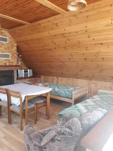 Habitación con mesa y sillas en una cabaña de madera en Alyvos en Ignalina