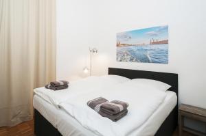 a bedroom with a white bed with towels on it at Appartements an der Elbphilharmonie contactless Check in in Hamburg