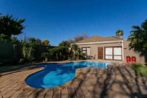 a swimming pool in front of a house at Royl Court Guesthouse in Kimberley