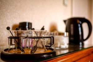 Un mostrador con vasos y una cafetera. en B&B Ter Vesten, en Ypres