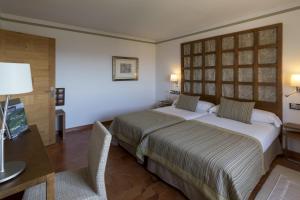 a hotel room with two beds and a television at Parador de Toledo in Toledo