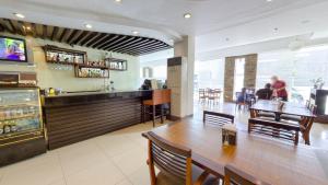 a restaurant with a long table and a bar at O Hotel in Bacolod