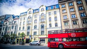 un bus rouge à deux étages garé devant un bâtiment dans l'établissement Hestia Hotel Jugend, à Riga