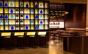 a restaurant with a bar with a wall of stained glass at Lemon Tree Premier City Center in Gurgaon