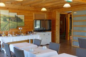 comedor con mesas y sillas blancas y TV en Hôtel Valery en Montélier