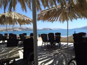 a group of chairs and tables on a beach with the ocean at Nelany in Zubovići