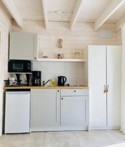 a kitchen with white cabinets and a microwave at 8 Sosen Pobierowo in Pobierowo