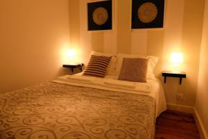 リスボンにあるLisbon Lights Apartmentsのベッドルーム1室(大型ベッド1台、ランプ2つ付)
