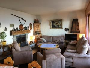 a living room with couches and a table and a fireplace at Pension Les Audannes in Anzère