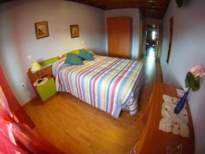 a small bedroom with a bed and a wooden floor at Hotel El Golobar in Reinosa
