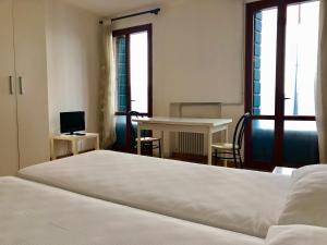 Schlafzimmer mit einem Bett, einem Tisch und einem Schreibtisch in der Unterkunft M14 Duomo Apartments in Padua