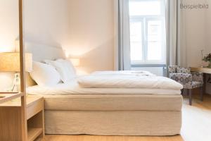 a bedroom with a bed with white sheets at Cottage Rheingau Hotel in Walluf