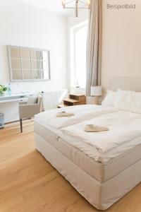 ein großes weißes Bett in einem weißen Schlafzimmer in der Unterkunft Cottage Rheingau Hotel in Walluf