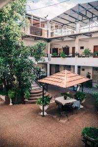 un patio con mesa y sombrilla frente a un edificio en Hotel Tia, en Salto