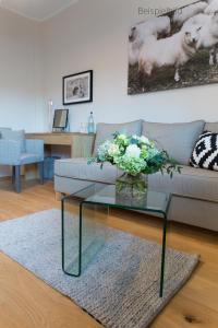 a living room with a couch and a glass table at Cottage Rheingau Hotel in Walluf