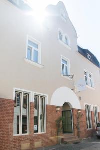 ein weißes Haus mit Ziegelwand in der Unterkunft Cottage Rheingau Hotel in Walluf