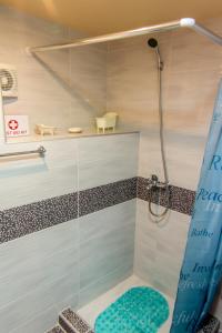 a bathroom with a shower with a blue shower curtain at Manto's House Lefkada in Évyiros
