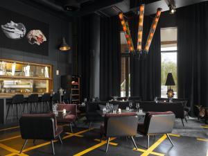 a dining room with tables and chairs and a chandelier at 25hours Hotel Hamburg HafenCity in Hamburg