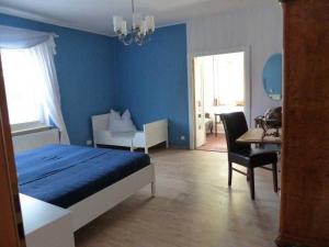 ツィノヴィッツにあるFerienwohnung Zinnowitzの青いベッドルーム(ベッド1台、テーブル、椅子付)