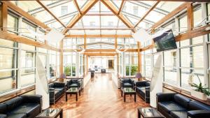 a large room with leather furniture and windows at Hestia Hotel Jugend in Rīga