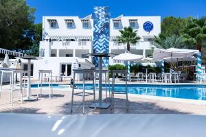 une piscine avec des tables et des parasols en face d'un hôtel dans l'établissement La Concha Soul Boutique Hotel, à Paguera