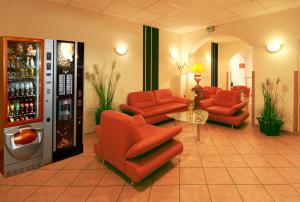 a lobby with red chairs and a drink machine at Hotel Constantin in Trier