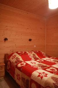 ein Schlafzimmer mit einem Bett in einem Holzzimmer in der Unterkunft la ratavelaiza in Champagny-en-Vanoise