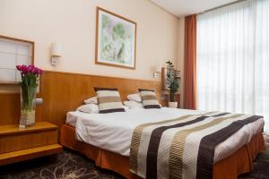 A bed or beds in a room at Hotel Lycium Debrecen