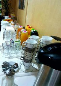 una larga mesa blanca con copas y bebidas. en Green House Hostel en Belgrado