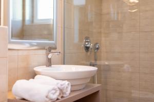 ein Badezimmer mit Waschbecken und Dusche mit Handtüchern in der Unterkunft Villa Neda in Malinska
