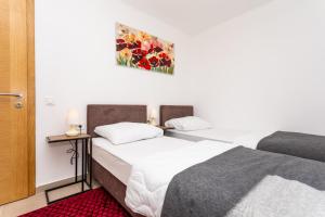 ein Schlafzimmer mit zwei Betten und einem Bild an der Wand in der Unterkunft Villa Neda in Malinska + 23 Fotos