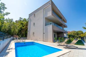 una casa con piscina al lado de un edificio en Villa Neda en Malinska