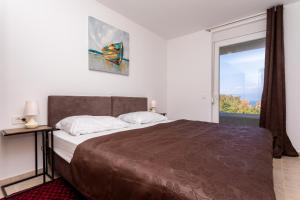 ein Schlafzimmer mit großem Bett und Fenster in der Unterkunft Villa Neda in Malinska