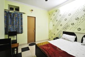 a bedroom with a bed and a desk in it at Satkar Hotel in Jaipur