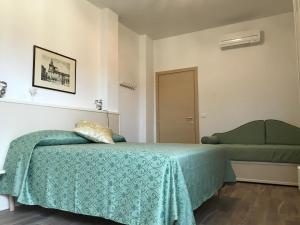 ボローニャにあるGuest House in Piazzaのベッドルーム(緑のベッド1台、ソファ付)